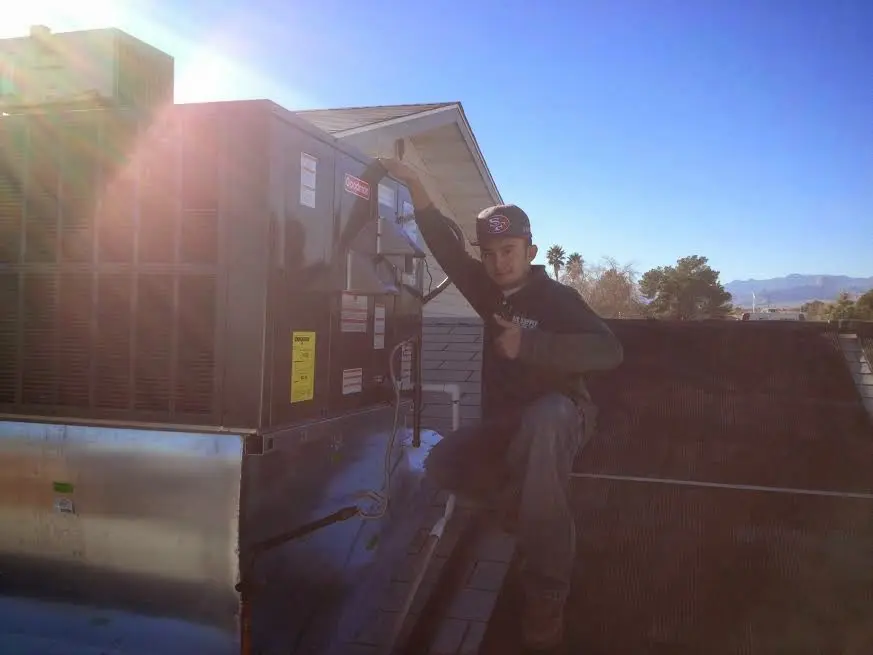 HVAC technician performing AC Tune-Up on a rooftop unit in Morrisville